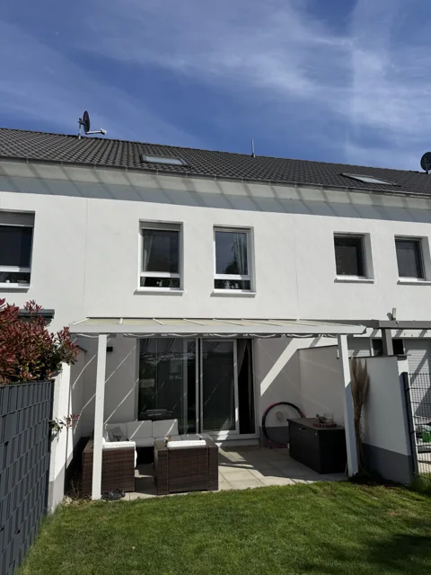Haus mit Terrasse und Garten bei Sonnenschein